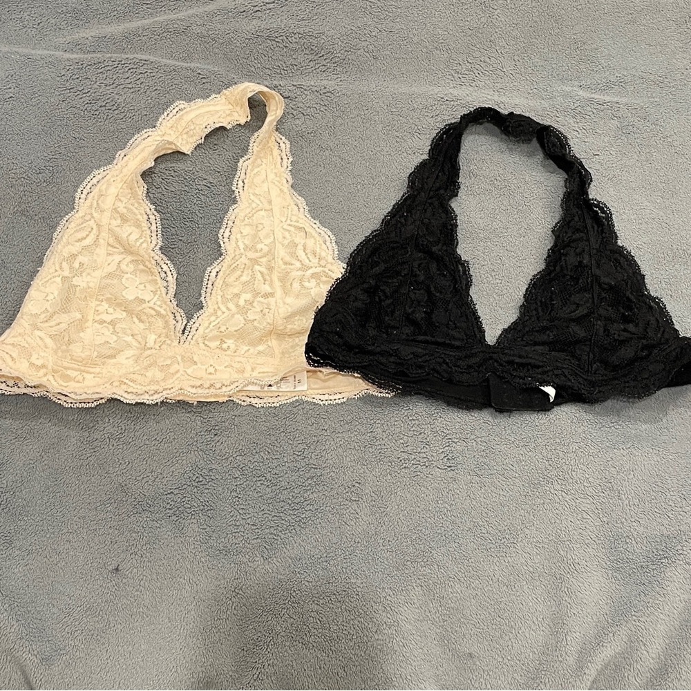 Two lacy halter bralettes: one black, one white. Size medium.